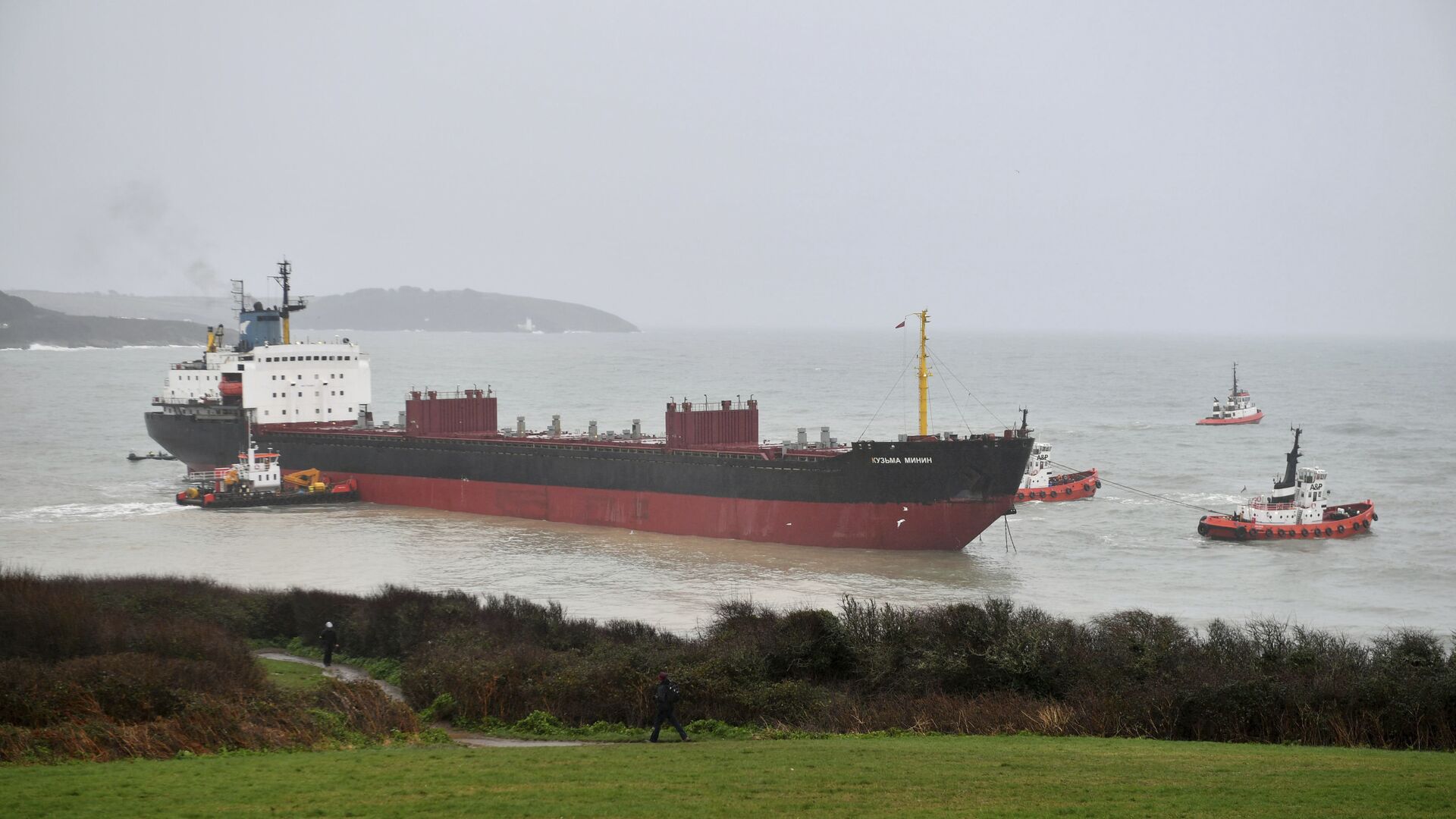 Tugs manoeuvre the Kuzma Minin, a 16,000-tonne Russian cargo ship, as attempts are made to refloat it after it ran aground off Gyllyngvase Beach in Falmouth, south west England, Tuesday Dec. 18, 2018 - Sputnik International, 1920, 29.03.2022