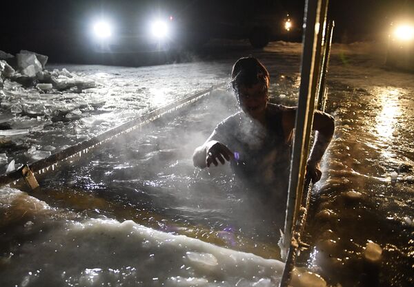 A woman is bathing in an ice hole in a village in Novosibirsk Region A woman is bathing in an ice hole in a village in Novosibirsk Region - Sputnik International