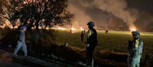 Military personnel watch as flames engulf an area after a ruptured fuel pipeline exploded, in the municipality of Tlahuelilpan, Hidalgo, Mexico, near the Tula refinery of state oil firm Petroleos Mexicanos (Pemex), January 18, 2019 in this handout photo provided by the National Defence Secretary (SEDENA) - Sputnik International
