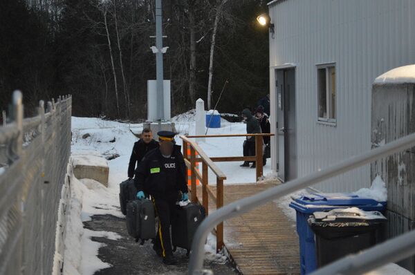 Canadian police officer helps illegal migrant to carry his luggage Canadian police officer helps illegal migrant to carry his luggage - Sputnik International