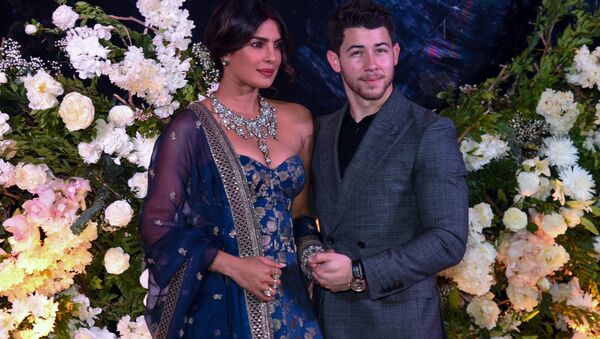 Indian Bollywood actress Priyanka Chopra (L) and US musician Nick Jonas, who were recently married, pose for a picture during a reception in Mumbai on December 19, 2018 - Sputnik International