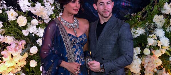 Indian Bollywood actress Priyanka Chopra (L) and US musician Nick Jonas, who were recently married, pose for a picture during a reception in Mumbai on December 19, 2018 - Sputnik International
