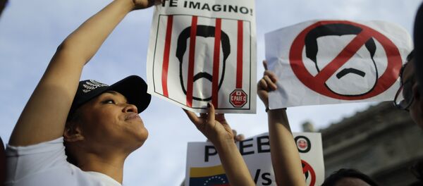 Venezuelan anti-government protesters hold signs against Venezuelan President Nicolas Maduro during a demonstration in Buenos Aires, Argentina, Wednesday, Jan. 23, 2019 - Sputnik International