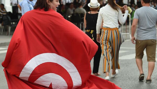 A Tunisians woman wears a national flag during a demonstration to mark Tunisia's Women's Day and to demand equal inheritance rights between men and women on August 13, 2018, in the capital Tunis - Sputnik International