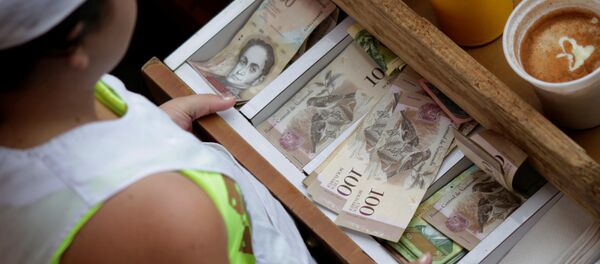 A cashier receives Venezuelan bolivar notes at a market in downtown Caracas, Venezuela A cashier receives Venezuelan bolivar notes at a market in downtown Caracas, Venezuela - Sputnik International