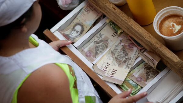 A cashier receives Venezuelan bolivar notes at a market in downtown Caracas, Venezuela - Sputnik International