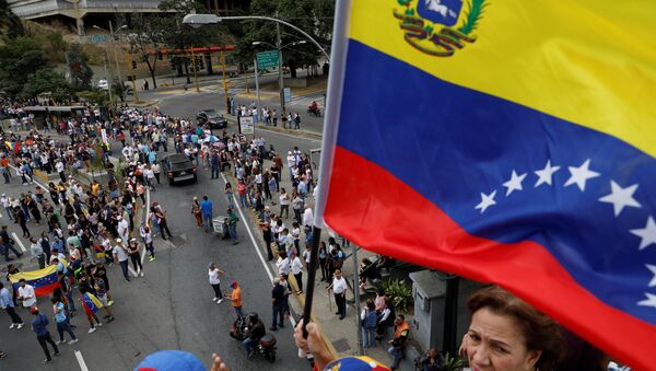 A supporter of Venezuelan opposition leader and self-proclaimed interim president Juan Guaido holds a flag - Sputnik International