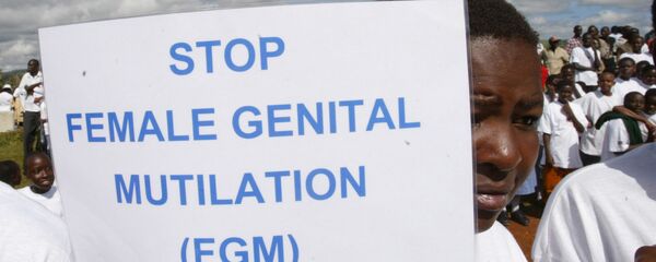 A woman in Kenya holds up a sign against FGM during a demonstration - Sputnik International