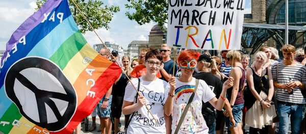 Two women hold up a sign reading One day we'll march in Iran while taking part in the Christopher Street Parade in Hamburg, northern Germany, on August 2, 2014 - Sputnik International