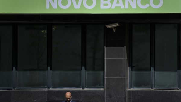 A man stands under a logo of Novo Banco Portuguese bank in Lisbon on March 31, 2017. - Sputnik International