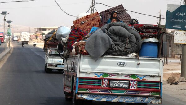 Syrians ride with their belongings in trucks as they head to safer areas in the town of Khan Sheikhun. - Sputnik International