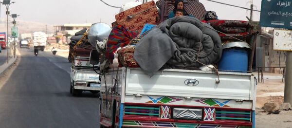 Syrians ride with their belongings in trucks as they head to safer areas in the town of Khan Sheikhun. Syrians ride with their belongings in trucks as they head to safer areas in the town of Khan Sheikhun. - Sputnik International
