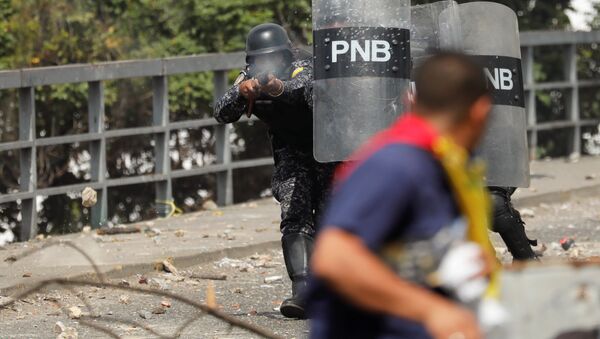 A National Police officer fires rubber bullets during a protest against Venezuelan President Nicolas Maduro's government in Caracas, Venezuela January 23, 2019 - Sputnik International