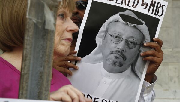 People hold signs during a protest at the Embassy of Saudi Arabia about the disappearance of Saudi journalist Jamal Khashoggi - Sputnik International