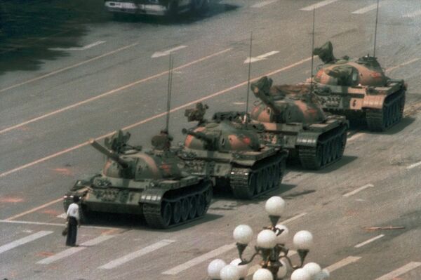 Tank Man blocks a column of Type 59 tanks heading east on Beijing's Chang'an Boulevard (Avenue of Eternal Peace) near Tiananmen Square during the Tiananmen Square protests of 1989. This photo was taken from the sixth floor of the Beijing Hotel, about half a mile away, through a 400 mm lens. The name and fate of the man is unknown - Sputnik International