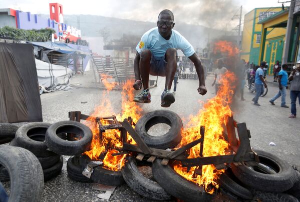 A Protester Jumps Over a Burning Barricade in Haiti - Sputnik International