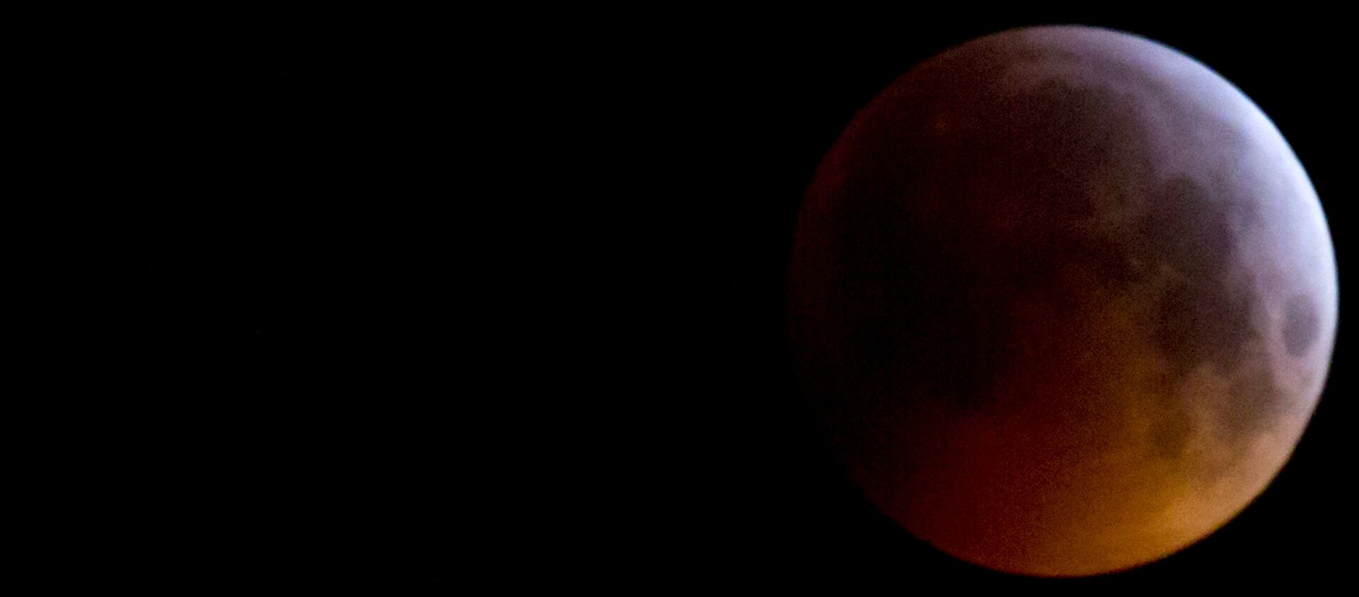 The Super Blood Wolf Moon eclipse in Antwerp, Belgium, Monday, Jan. 21, 2019. The eclipse takes place when the full moon is at or near the closest point in its orbit to Earth, a time popularly known as a supermoon. This means the Moon is deeper inside the umbra shadow and therefore may appear darker. - Sputnik International, 1920, 01.05.2020
