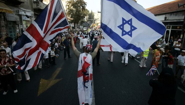A Christian Evangelical from the United Kingdom waves Israeli and British flags during a parade in celebration of the Jewish holiday of Sukkoth, in downtown Jerusalem, 02 October 2007 - Sputnik International