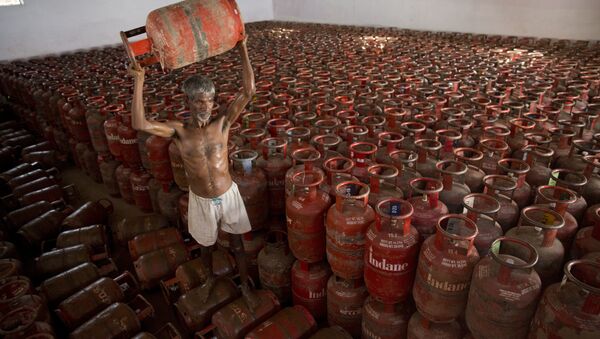 An Indian laborer sorts liquefied petroleum gas (LPG) cylinders used for cooking at a warehouse after downloading them from a truck in Allahabad, India (File) - Sputnik International