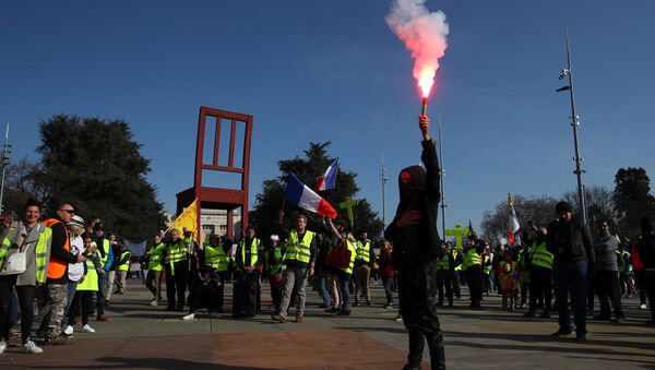A person holds up a flare as people wearing yellow vests demonstrate outside the United Nations ahead of the Human Rights Council in Geneva, Switzerland, February 20, 2019 - Sputnik International