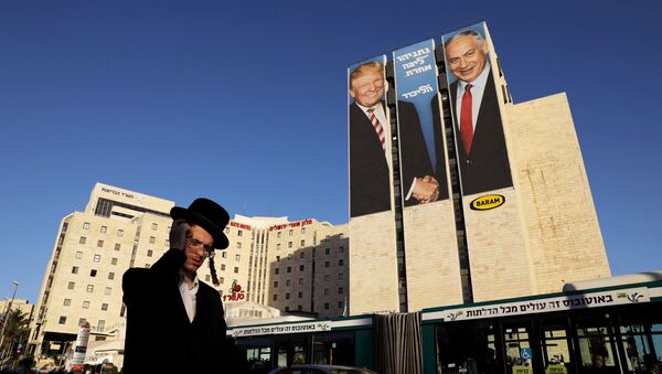 A man walks past a Likud election campaign billboard, depicting U.S. President Donald Trump shaking hands with Israeli Prime Minister Benjamin Netanyahu, in Jerusalem February 4, 2019 - Sputnik International