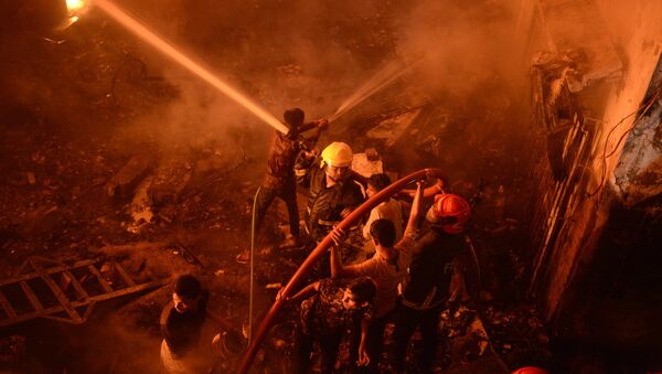 In this Wednesday, Feb. 20, 2019, photo, firefighters try to douse flames in Dhaka, Bangladesh. - Sputnik International