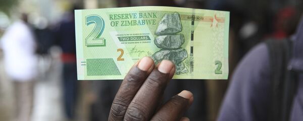 A man shows a new note introduced by the Reserve Bank of Zimbabwe in Harare, Monday, Nov, 28, 2016 - Sputnik International