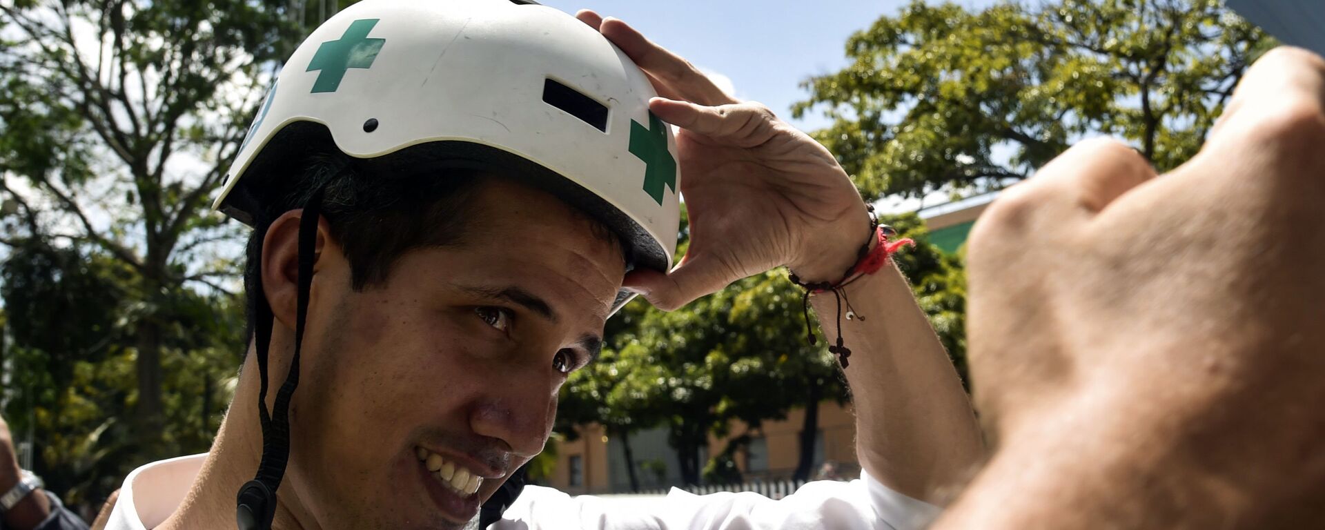 Venezuelan opposition leader and self declared acting president Juan Guaido wears a Green Cross helmet as he posses for a picture with volunteers of the movement Aid and Freedom Venezuela Coalition after delivering a speech in Caracas, on February 16, 2019 - Sputnik International, 1920, 21.02.2019