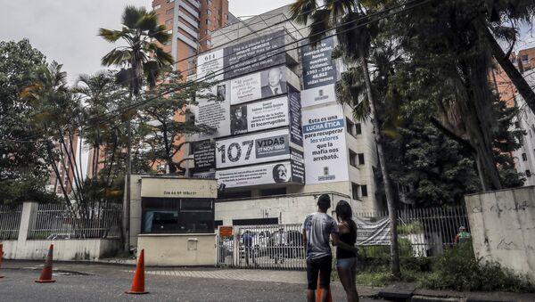 A couple looks at the Monaco building, which was once home to Colombian drug lord Pablo Escobar, as it is covered with pictures of victims of his Medellin Cartel, in Medellin, Colombia, on December 11, 2018 - Sputnik International