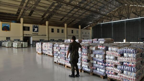 A Brazilian soldier walks near packages of rice and sugar that are part of the humanitarian aid for Venezuela, at Ala 7 air base in Boa Vista, Roraima state, Brazil in the border with Venezuela, on February 22, 2019. - Sputnik International