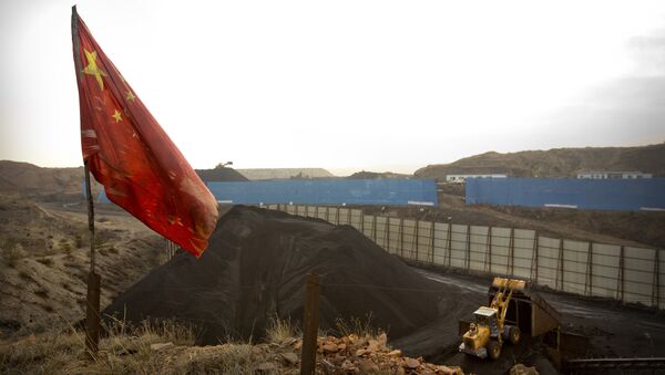 In this Wednesday, Nov. 4, 2015 photo, a Chinese flag moves in the breeze as a loader moves coal at a coal mine near Ordos in northern China's Inner Mongolia Autonomous Region. - Sputnik International