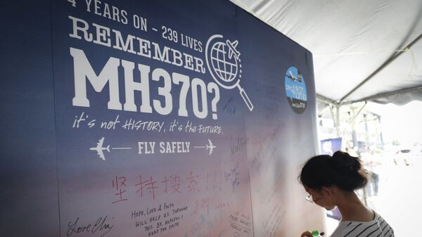 A girl writes a condolence message during the Day of Remembrance for MH370 event in Kuala Lumpur, Malaysia.  - Sputnik International