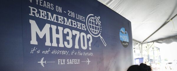 A girl writes a condolence message during the Day of Remembrance for MH370 event in Kuala Lumpur, Malaysia. - Sputnik International