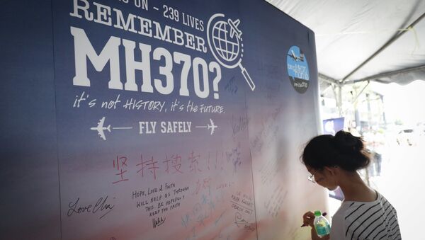 A girl writes a condolence message during the Day of Remembrance for MH370 event in Kuala Lumpur, Malaysia.  - Sputnik International