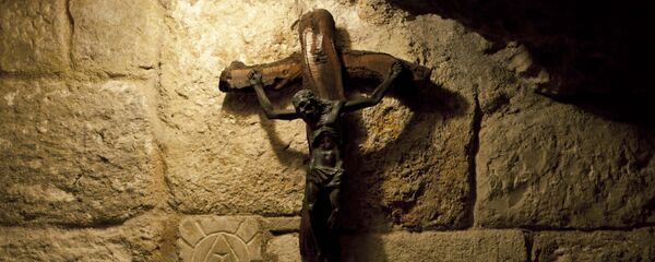 In this Tuesday Dec. 10, 2013 photograph, a crucifix is seen in the St. Jerome's Cave underneath the Church of the Nativity in the West Bank city of Bethlehem. In this Tuesday Dec. 10, 2013 photograph, a crucifix is seen in the St. Jerome's Cave underneath the Church of the Nativity in the West Bank city of Bethlehem. - Sputnik International