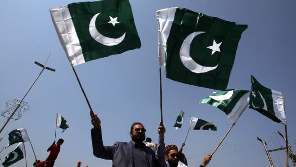 People carry national flags as they celebrate, after Pakistan shot down two Indian military aircrafts, in Lahore, Pakistan February 27, 2019 - Sputnik International
