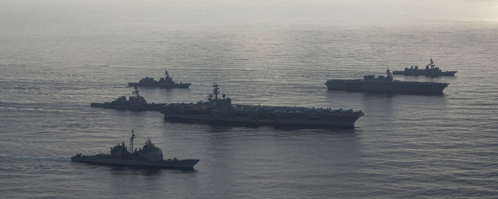 The aircraft carrier USS Ronald Reagan (CVN 76), second from bottom, lead ship of the Ronald Reagan Carrier Strike Group, the guided-missile cruiser USS Antietam (CG 54), bottom, and the guided-missile destroyer USS Milius (DDG 69), left, conduct a photo exercise with the Japan Maritime Self-Defense Force (JMSDF) helicopter destroyer JS Kaga (DDH 184), second from top, and the JMSDF destroyers JS Inazuma (DD 105) and JS Suzutsuki (DD 117). The Ronald Reagan Carrier Strike Group is forward-deployed to the U.S. 7th Fleet area of operations in support of security and stability in the Indo-Pacific region. - Sputnik International, 1920, 16.07.2023