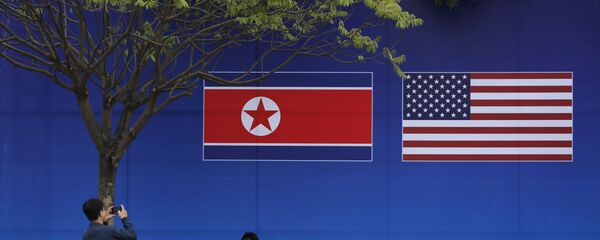 People take pictures in front of a poster featuring the upcoming second summit between the U.S. and North Korea in Hanoi, Vietnam - Sputnik International