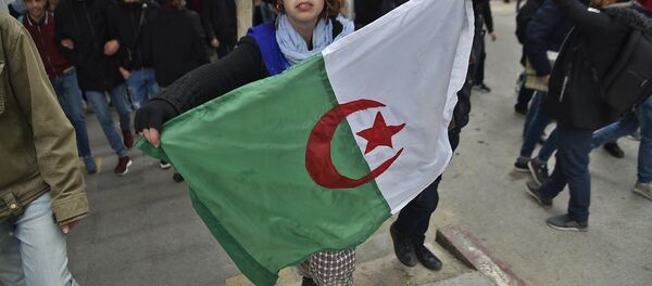 A woman holds an Algerian flag during demonstrations against President Bouteflika in Algiers on 26 February - Sputnik International
