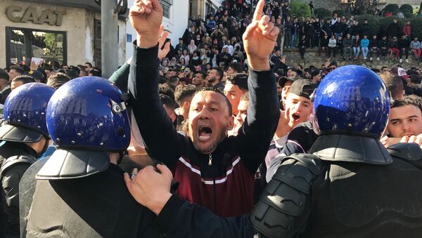 A man gestures and shouts near riot police during a protest against President Abdelaziz Bouteflika's plan to extend his 20-year rule by seeking a fifth term in April elections in Algiers, Algeria, March 1, 2019. - Sputnik International