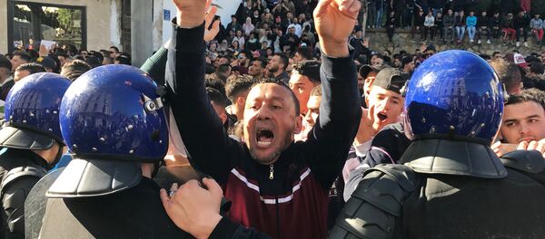 A man gestures and shouts near riot police during a protest against President Abdelaziz Bouteflika's plan to extend his 20-year rule by seeking a fifth term in April elections in Algiers, Algeria, March 1, 2019. A man gestures and shouts near riot police during a protest against President Abdelaziz Bouteflika's plan to extend his 20-year rule by seeking a fifth term in April elections in Algiers, Algeria, March 1, 2019. - Sputnik International