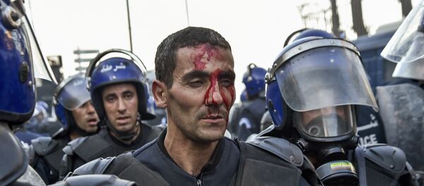 A member of the Algerian security forces is seen with a bloodied face as riot forces respond to protests in the capital Algiers on March 1, 2019, against ailing President Abdelaziz Bouteflika's bid for a fifth term in power. - Sputnik International