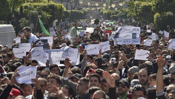 Algerians march with protest sings reading peaceful, and leave means leave in Arabic, during a rally against ailing President Abdelaziz Bouteflika's bid for a fifth term in power, in the capital Algiers on March 1, 2019. - Sputnik International
