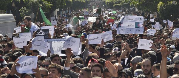 Algerians march with protest sings reading peaceful, and leave means leave in Arabic, during a rally against ailing President Abdelaziz Bouteflika's bid for a fifth term in power, in the capital Algiers on March 1, 2019. - Sputnik International