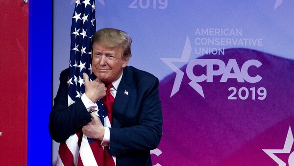 President Donald Trump hugs the American flag as he arrives to speak at Conservative Political Action Conference, CPAC 2019, in Oxon Hill, Md., Saturday, March 2, 2019. - Sputnik International