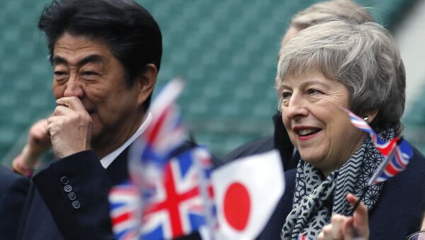 Britain's Prime Minister Theresa May, right and Japanese Prime Minister Shinzo Abe are greeted by Chase Bridge Primary School children waving flags, during a visit to Twickenham Rugby Stadium, in London, Thursday, Jan. 10, 2019. - Sputnik International