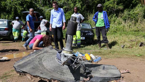 Local ecological association members and volunteers stand behind debris found on August 11, 2015 in the eastern part of Sainte-Suzanne, on France's Reunion Island in the Indian Ocean, during search operations for the missing MH370 flight conducted by French army forces and local associations. - Sputnik International