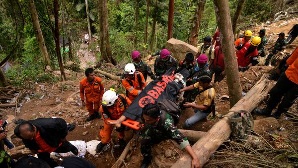 Rescue workers carry a body bag containing a victim after the landslide of the illegal gold mine at Bolaang Mongondow Regency in North Sulawesi, Indonesia, February 28, 2019 - Sputnik International