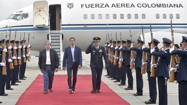 In this photo released by Colombia's presidential press office, Venezuelan opposition leader Juan Guaido, who declared himself interim president of Venezuela, is escorted by Air Force Gen. Luis Carlos Cordoba, right, and Colombian Foreign Minister Carlos Holmes Trujillo during a welcome ceremony for him at the military airport in Bogota, Colombia, Sunday, Feb. 24, 2019 - Sputnik International