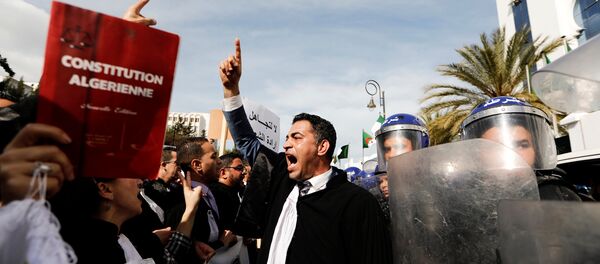 Lawyers chant slogans as they gesture near riot police outside the constitutional council during a protest denouncing an offer by President Abdelaziz Bouteflika to run in elections next month but not to serve a full term if re-elected, in Algiers, Algeria March 7, 2019. - Sputnik International